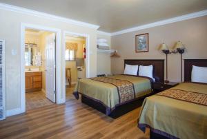 Un pat sau paturi într-o cameră la Charm Motel & Suites
