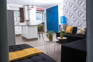 ein Wohnzimmer mit einem Sofa und einer Küche in der Unterkunft 2 bedroom modern house in Zomba in Zomba