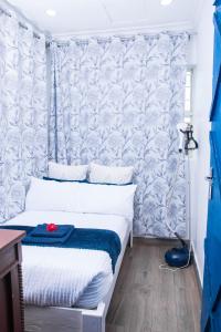 Schlafzimmer mit einem Bett mit einer blauen und weißen Tapete in der Unterkunft 2 bedroom modern house in Zomba in Zomba