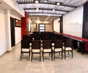 una sala de conferencias con una mesa larga y sillas en Hotel Santiago de Compostella Suites, en Cuenca