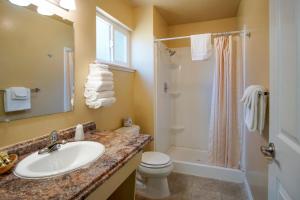 Burney的住宿－Charm Motel & Suites，一间带水槽、淋浴和卫生间的浴室
