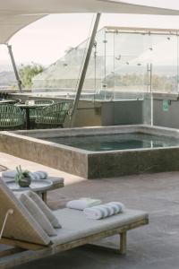 a swimming pool with two lounge chairs and a table at Hotel Apapacho Boutique in San Miguel de Allende