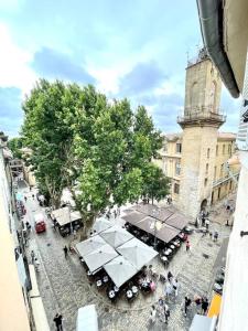 - une vue sur une rue avec des tables et un arbre dans l'établissement Ravissant appartement au cœur d’Aix, à Aix-en-Provence