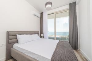 a bedroom with a bed and a large window at Skyline Vista in Becici