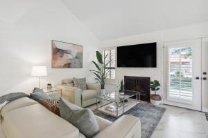 a white living room with a couch and a fireplace at Palm Desert Condo Country Club Perks and Pond Views in Palm Desert