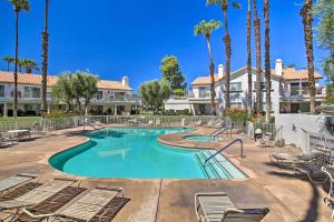 a swimming pool with chairs and palm trees at Palm Desert Condo Country Club Perks and Pond Views in Palm Desert