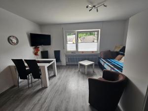 sala de estar con mesa y sofá en Appart-Ascolino, en Siebenbach