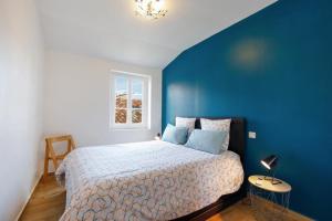 um quarto com uma cama com uma parede azul em Appartements climatisés - Vieil Antibes em Antibes