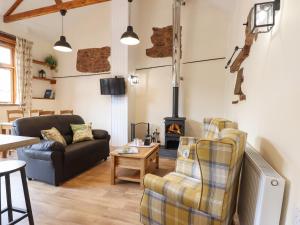 a living room with a couch and a fire place at Quoit X Barn in Tiverton