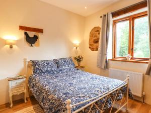 a bedroom with a bed and a window at Quoit X Barn in Tiverton