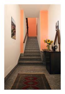 korytarz ze schodami z pomarańczowymi ścianami i wazonem kwiatów w obiekcie Casa Vacanze Piazza Padella w mieście San Severino Marche