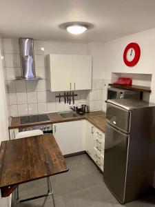 La cuisine est équipée d'une table en bois et d'un réfrigérateur en acier inoxydable. dans l'établissement InOut Olsztyn, à Olsztyn