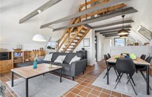 a living room with a couch and a table at Nice Home In Hvide Sande With Sauna in Bjerregård