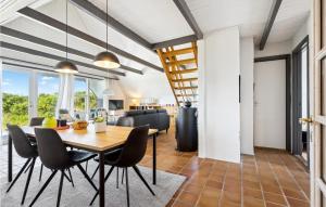 a dining room and living room with a table and chairs at Nice Home In Hvide Sande With Sauna in Bjerregård