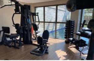 a gym with exercise equipment in a room with a window at Rio Centro Convention Barra Olimpica in Rio de Janeiro