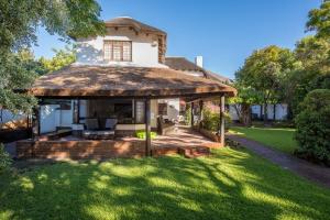 an old house with a thatched roof on a lawn at Mead, Pinelands in Cape Town