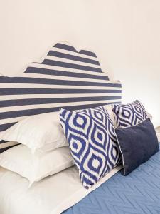 un letto con cuscini bianchi e blu di Villa Nannina a Positano