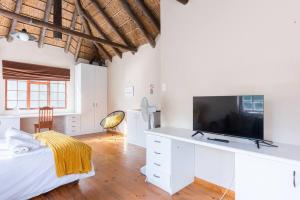 a bedroom with a bed and a flat screen tv at Mead, Pinelands in Cape Town