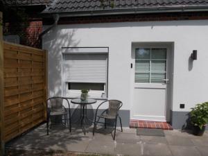 eine Terrasse mit einem Tisch und Stühlen vor einem Haus in der Unterkunft Ferienwohnung Krümel in Emden