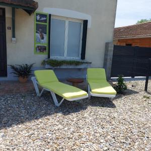 2 sillas sentadas en un patio frente a una casa en Charmant appartement proche Carcassonne, en Montgradail