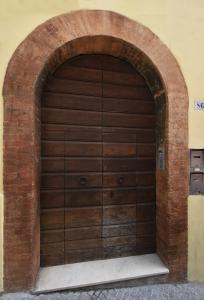 uma porta de garagem de madeira numa parede de tijolos em La Casa del Borgo Antico em Spoleto