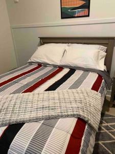 a bed with a striped comforter in a bedroom at Comfy Cozy and Cute in Baltimore