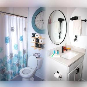 a bathroom with a toilet and a sink and a mirror at Comfy Cozy and Cute in Baltimore