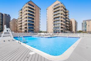 a swimming pool with two apartment buildings in the background at Sea Colony Harbour House II in Bethany Beach