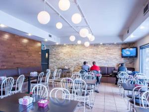 a restaurant with people sitting at tables and chairs at Motel Mistral in Rouyn-Noranda