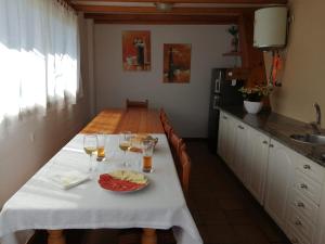 uma cozinha com uma mesa com copos de vinho e queijo em Desconectaengalicia Casa Portonovo em Portonovo