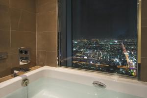 a bathroom with a bath tub with a window at Osaka Marriott Miyako Hotel in Osaka