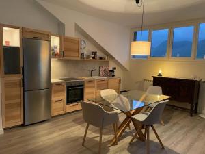 uma cozinha com uma mesa e cadeiras e um frigorífico de aço inoxidável em Apartamento en Posada de Llanes em Posada de Llanes