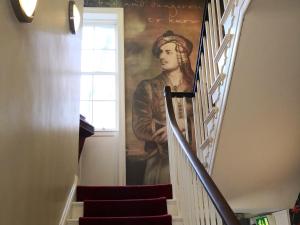 a painting of a man walking down a staircase at The Commercial Bar & Hotel in Chester