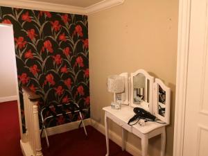 een kamer met een tafel met een spiegel en een stoel bij The Commercial Bar & Hotel in Chester