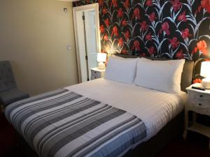 a bedroom with a bed with a floral wallpaper at The Commercial Bar & Hotel in Chester