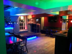 um bar com mesas e cadeiras numa sala com luzes em The Commercial Bar & Hotel em Chester