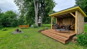 eine Holzterrasse mit einem Tisch und Stühlen im Hof in der Unterkunft Mustvee Puhkemaja in Mustvee