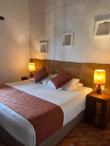 a bedroom with a large bed with two lamps at Hotel Hicasua y Centro de Convenciones in Barichara