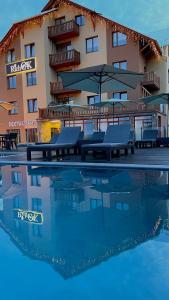 um hotel com mesas e guarda-sóis ao lado de uma piscina em Rich OAK - Багатий Дуб em Yablunytsya