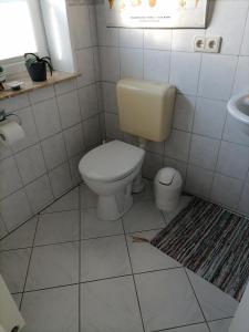 La salle de bains est pourvue de toilettes et d'un lavabo. dans l'établissement Gästezimmer Mitten in Angeln, à Mittelangeln