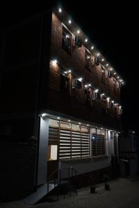 a building with lights on the side of it at night at Center Side in Prizren