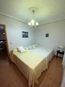 a bedroom with two beds and a chandelier at Finca y Casa Rural Los Huertos in Caracuel +42 photos