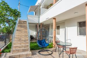 een patio met een tafel en stoelen en een trap bij Apartmani Medovic in Ulcinj