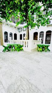 two green picnic tables in front of a building at Serce Konagi in Urfa