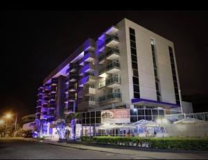 a building with purple lights on it at night at Flat em frente a praia Macaé in Macaé