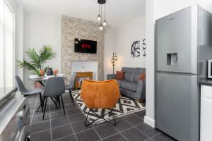 a kitchen and living room with a table and a couch at Host Liverpool - Stadium Side by Anfield, family home from home in Liverpool