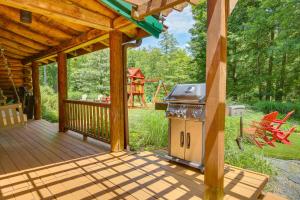 a wooden deck with a grill and a playground at Accord Vacation Rental with Pool and Hot Tub! in Accord