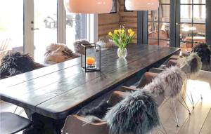uma mesa de madeira com cadeiras e um vaso de flores em 5 Bedroom Gorgeous Home In Tynset em Tynset