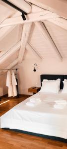 een slaapkamer met een groot wit bed op een zolder bij Porto Enetiko in Nafpaktos