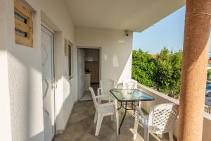 a small balcony with a table and chairs on it at Apartmani Medovic in Ulcinj